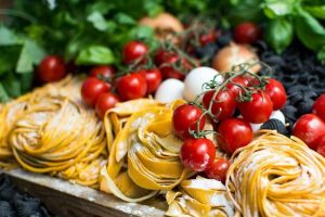 Home Italiaanse keuken ingrediënten waaronder olijfolie, tomaten en mozzarella die de aantrekkingskracht van Italiaanse gerechten